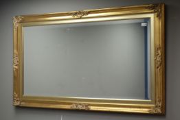 Rectangular bevelled edged mirror in swept gilt frame,