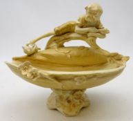 Royal Dux figural footed bowl decorated with a young boy laid on a branch,