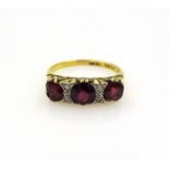 Three stone garnet and diamond gold ring stamped 18ct Condition Report Approx 3.