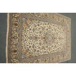 Persian Kashan ivory ground rug, blue floral design with repeating border,