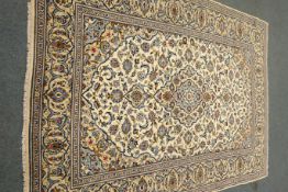 Persian Kashan ivory ground rug, blue floral design with repeating border,