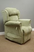 Electric reclining armchair upholstered in green fabric,