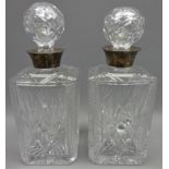 Pair of facet and fan cut square glass decanters with silver collars, hallmarked Birmingham 1957,