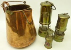 Three brass miners type safety lamps and a copper jug,