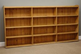Large early 20th century waxed pine open bookcase, three sections with three tiers, W233cm, H116cm,