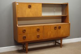 1970s teak sideboard, sliding glass doors and fall front above two drawers and double cupboard,