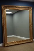 Large rectangular bevelled edge wall mirror in ornate swept gilt frame,