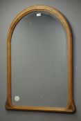Pine arched top framed bevelled edged mirror,