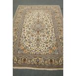 Persian Kashan ivory ground rug, blue floral design with repeating border,