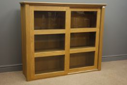 John Lewis light oak cabinet fitted with two sliding glazed doors, W134cm, H113cm,