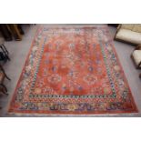 Early 20th century Chinese washed woollen carpet, peach ground decorated with floral motifs,