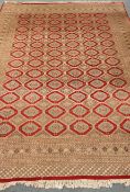 Persian Bokhara design hand knotted red ground rug, stepped lozenge, W320cm,