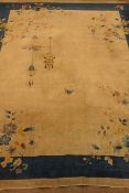 Large early 20th century Chinese carpet, beige ground with blue band border, decorated with flowers,