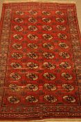 Persian Bokhara red ground rug, decorated with Guls,