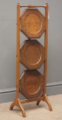 Early 20th century oak three tier folding cake stand, two arched supports, W30cm,
