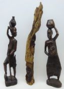 Pair of Zimbabwe carved ebony models of a man and woman, and a similar root carved with masks,