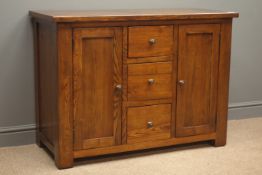 Oak sideboard, three drawers flanked by two cupboards enclosing shelves, square supports, W110cm,