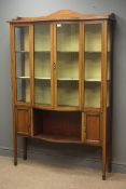 Edwardian inlaid mahogany display cabinet with bow fronted glazed doors enclosing three shelves,