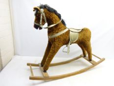 Plush covered rocking horse, with mane, bridal and saddle, on curving rockers,