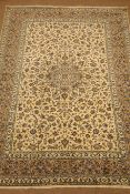 Persian Kashan ivory ground rug, trailing floral pattern with central medallion, repeating border,