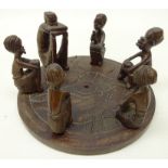 African Native carved hardwood group of six figures seated on circular base,