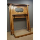 Arts & Craft period oak fire surround, projecting cornice, inset oval mirror, above shelf,