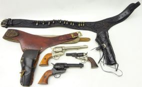 Two replica American Wild West revolvers in leather holster belts and another replica revolver (3)