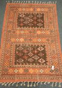 Indian pale red ground rug, decorated with geometric lozenge motifs,