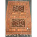 Indian pale red ground rug, decorated with geometric lozenge motifs,