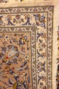 Persian Kashan ivory ground rug, trailing floral pattern with central medallion, repeating border,