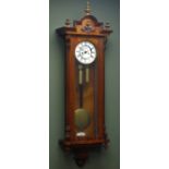 Late 19th century figured walnut Vienna wall clock, stepped arch pediment with turned finials,