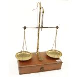 A take down balance by AVERY with brass pans and various weights contained in mahogany drawer/base
