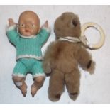 A small teddy with teether attached and a small plastic doll.
