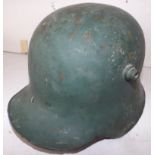 A German 1916 pattern helmet, patched and holed.