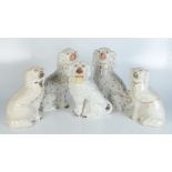 Two pairs of Victorian Staffordshire spaniels and a single spaniel holding a basket in his mouth,