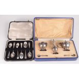 A silver three piece cruet with two matching spoons, cased,