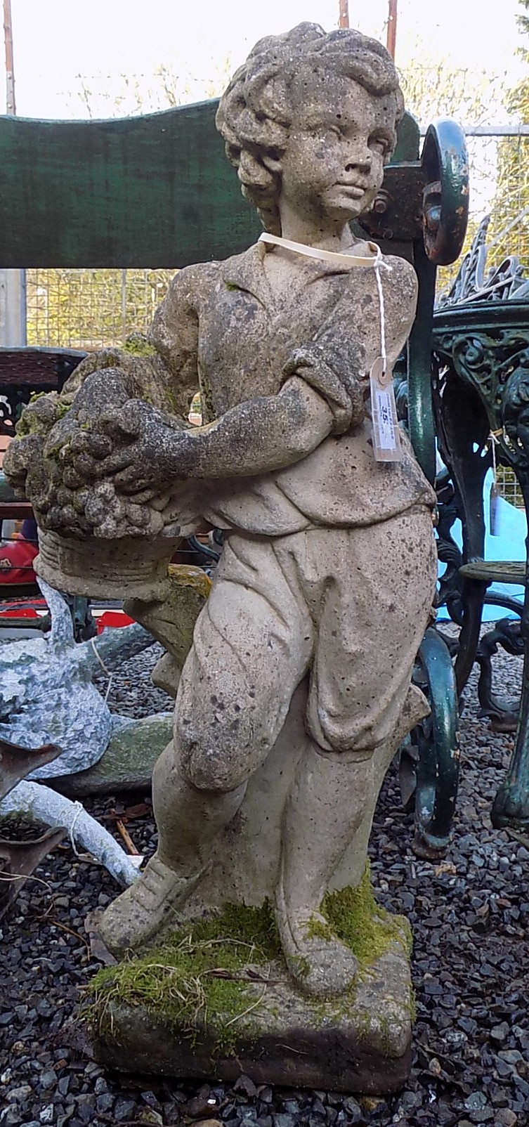 A composition garden statue of a boy holding a basket of fruit, on a square plinth base, 75cm.