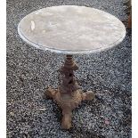A cast iron and marble topped circular garden table, height 73cm, diameter 59cm.