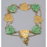 A high purity Chinese gold bracelet with alternating jade and gold heart shaped panels.