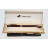 A black Waterman's fountain pen together with a burgundy Sheaffer Imperial fountain pen, boxed,