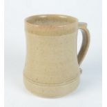 A Leach pottery cream glazed mug, impressed mark to base, height 11.7cm.