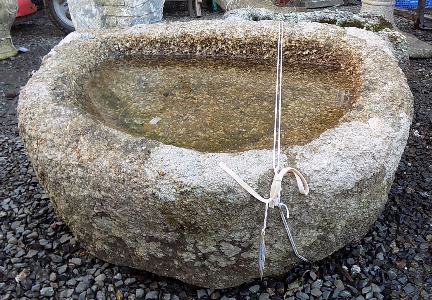 A granite trough, of demi lune form, height 32cm, width 73cm, depth 60cm.