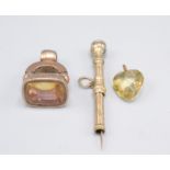 A gold propelling tooth pick , a gilt seal and a stone heart pendant.