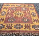 A Kelim rug, with a central saffron medallion flanked by four polychrome medallions,