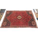 A Shiraz rug, South West Persia, the madder field with an ivory hexagonal central medallion,