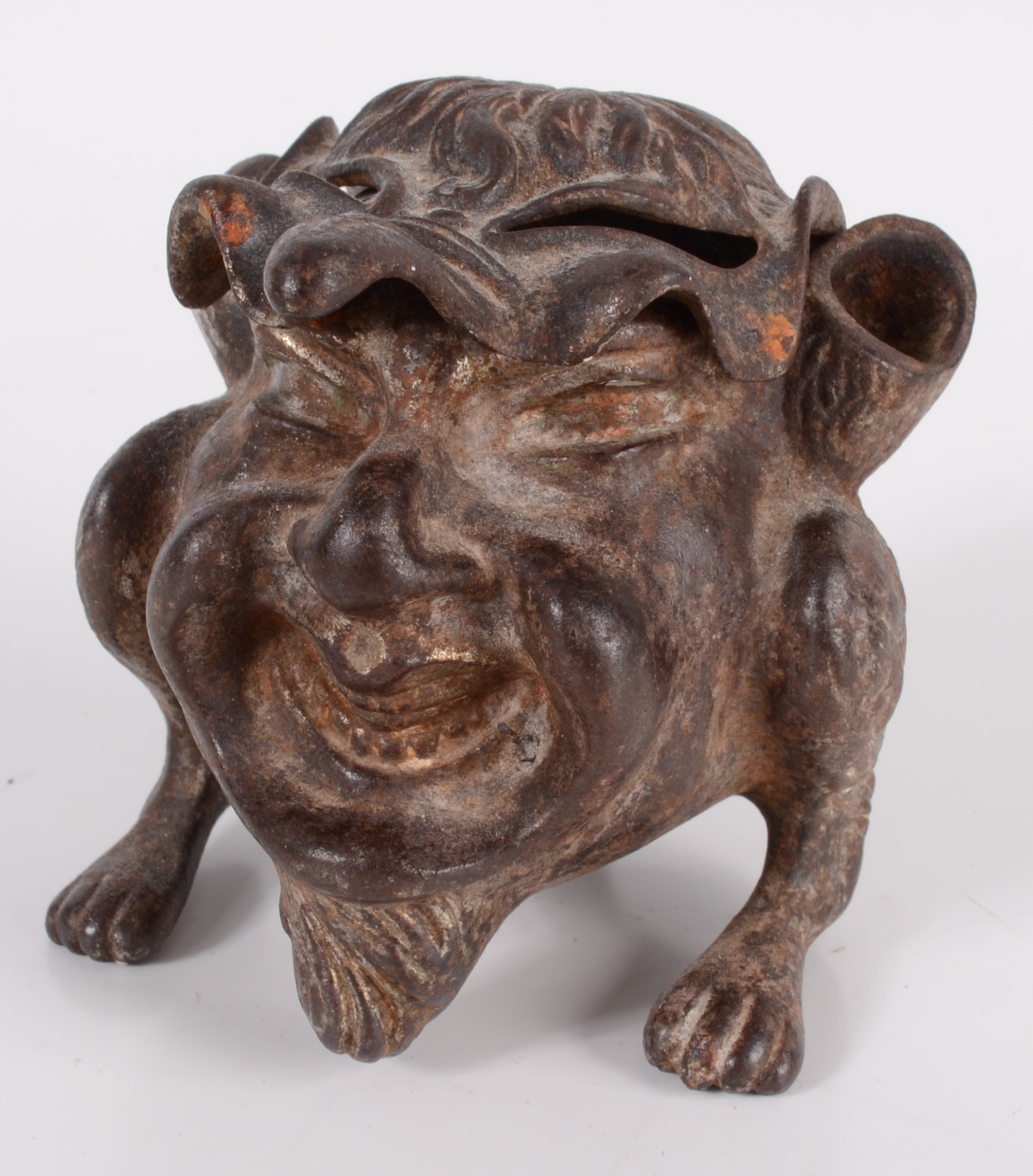 A cast iron inkwell in the form of a gargoyle, with glass liner, height 7.5cm, width 6.5cm, depth 8.