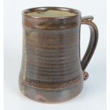 A Leach pottery brown glazed mug, impressed mark to base, height 12.3cm.