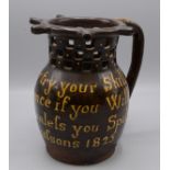 A brown glazed pottery puzzle jug, 19th century, inscribed 'Gentlemen now try your skill,