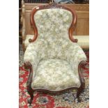 A Victorian gentlemans armchair, with a button upholstered back and arms above a padded seat,
