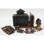 A Victorian black painted metal magic lantern, with brass lens, in a wooden case, length 55cm.